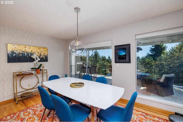 dining area featuring hardwood / wood-style flooring and a textured ceiling