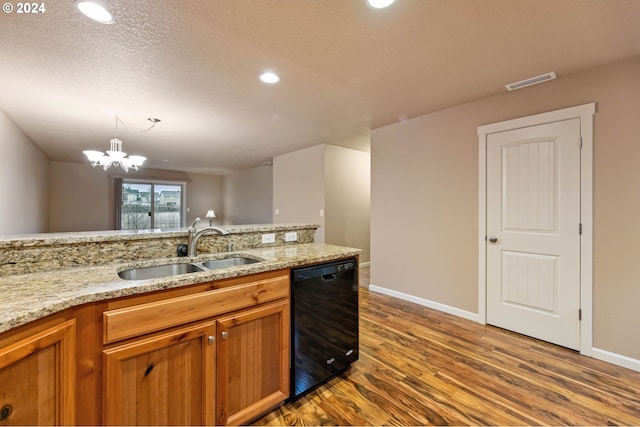 kitchen featuring light stone countertops, dishwasher, sink, an inviting chandelier, and hardwood / wood-style flooring