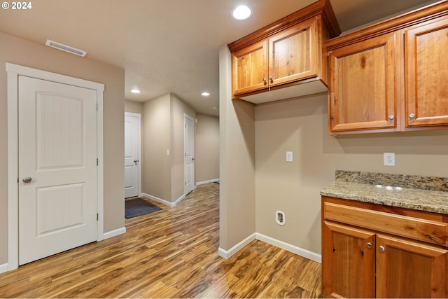 kitchen featuring light hardwood / wood-style flooring and light stone counters