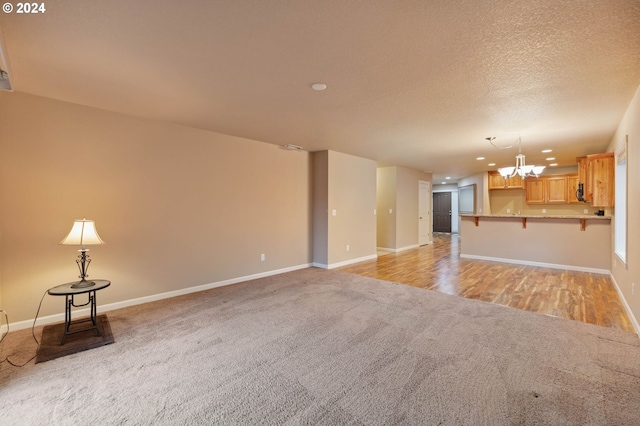 unfurnished living room with a notable chandelier and light carpet