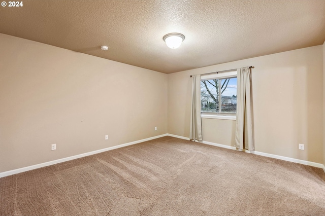 empty room featuring carpet and a textured ceiling