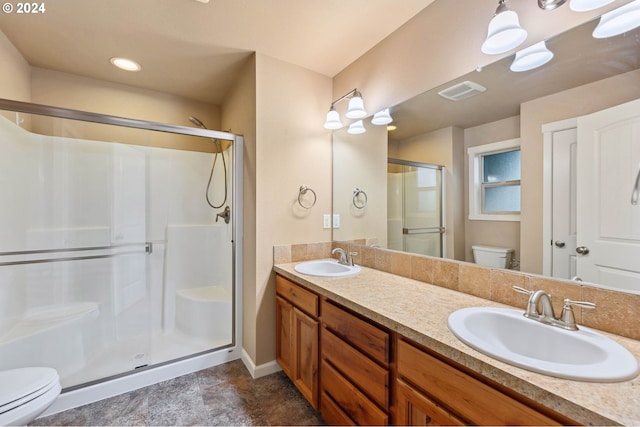 bathroom featuring vanity, toilet, and a shower with shower door