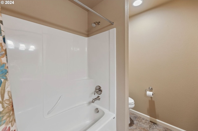 bathroom with bathing tub / shower combination and toilet