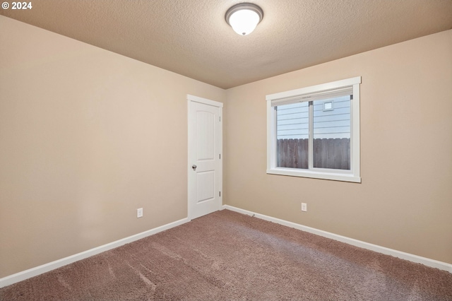 carpeted spare room with a textured ceiling