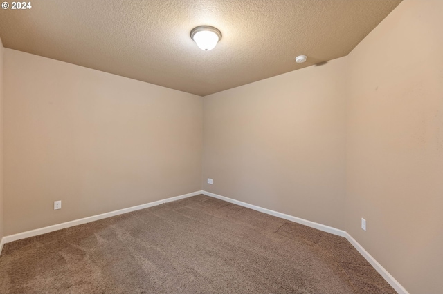 unfurnished room with carpet flooring and a textured ceiling