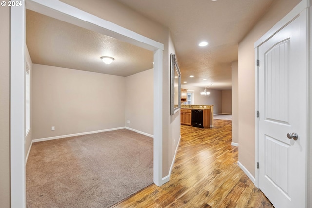 corridor featuring a chandelier and light hardwood / wood-style floors