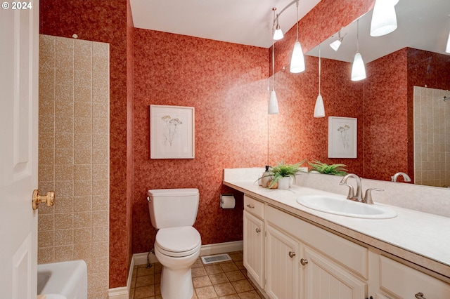 bathroom with a washtub, vanity, tile patterned floors, and toilet