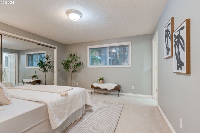 carpeted bedroom featuring a textured ceiling