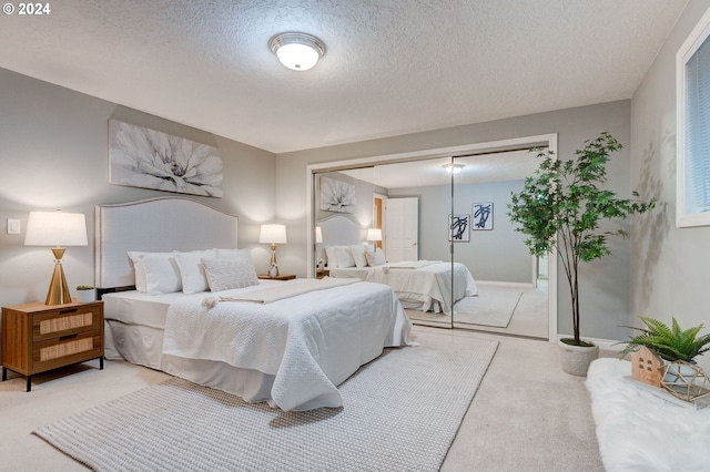 bedroom featuring a textured ceiling, light carpet, and a closet