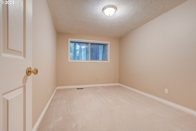 unfurnished room featuring a textured ceiling and carpet flooring