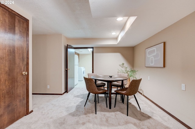 dining room featuring light colored carpet and a textured ceiling