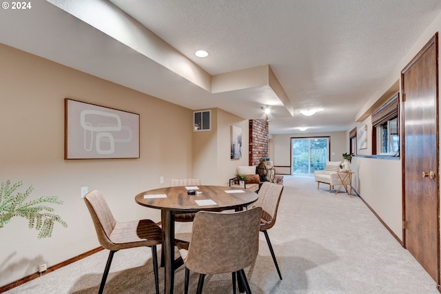 carpeted dining space with a textured ceiling