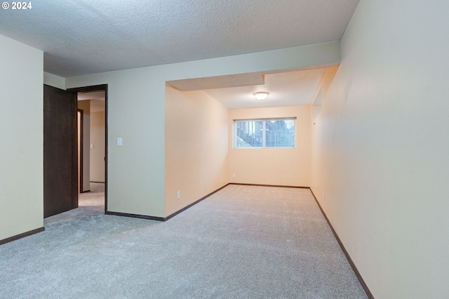 carpeted empty room with a textured ceiling