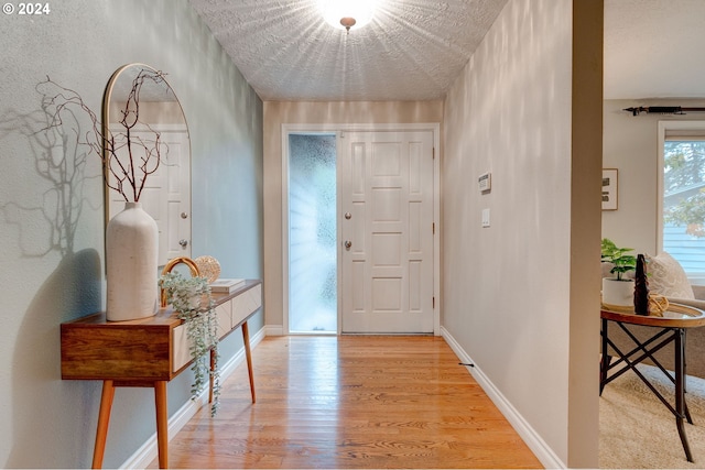 entryway with light hardwood / wood-style flooring and a textured ceiling