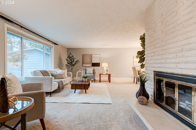 living room featuring a fireplace, light colored carpet, and a textured ceiling