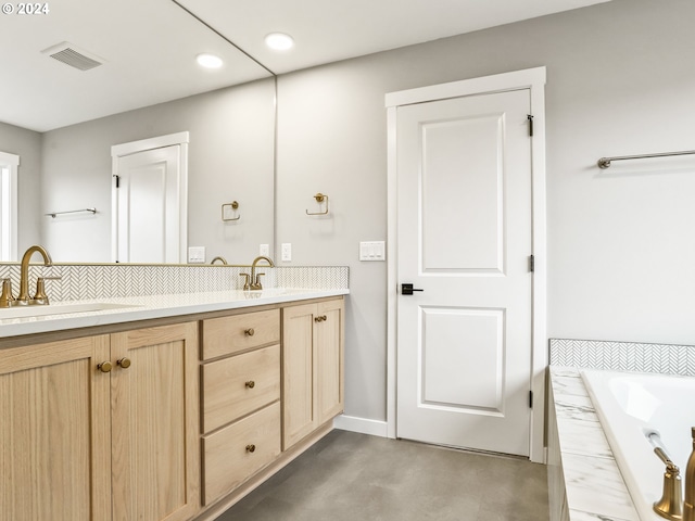 bathroom featuring tiled bath and vanity