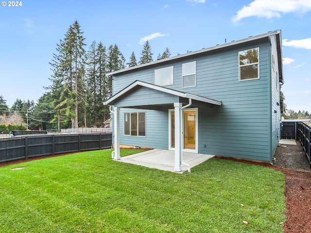 rear view of property with a lawn and a patio area