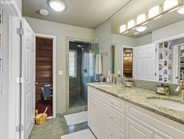 bathroom with vanity, a textured ceiling, and a tile shower