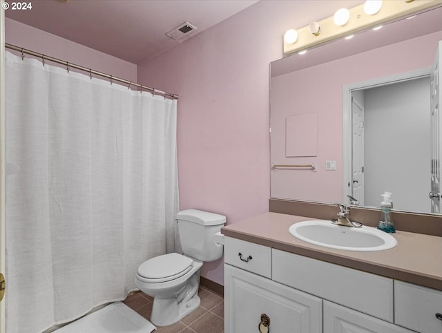 bathroom with tile patterned flooring, vanity, and toilet