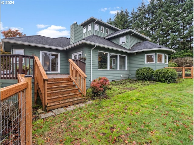 back of property featuring a lawn and a deck