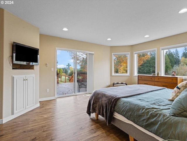 bedroom with access to outside and hardwood / wood-style floors