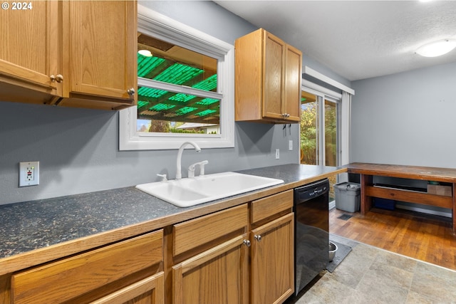 kitchen with dishwasher, sink, and a textured ceiling