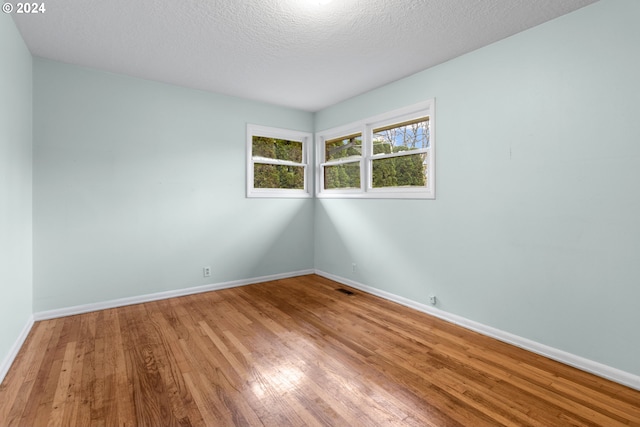 spare room with hardwood / wood-style flooring and a textured ceiling