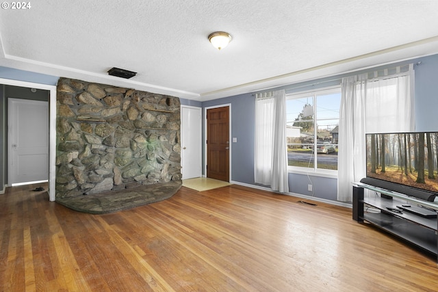 unfurnished living room with hardwood / wood-style flooring and a textured ceiling