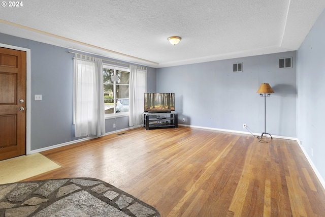 interior space featuring a textured ceiling and hardwood / wood-style flooring