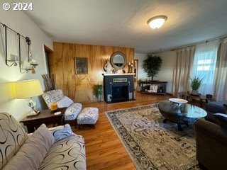 living room featuring hardwood / wood-style flooring and wooden walls