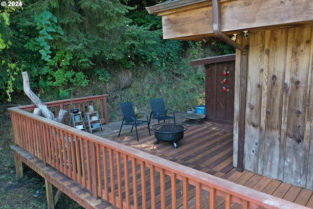 wooden deck featuring an outdoor fire pit