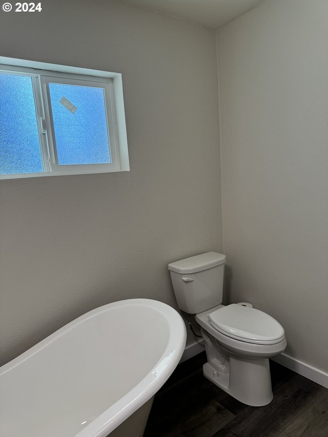 bathroom with a bath, wood-type flooring, and toilet