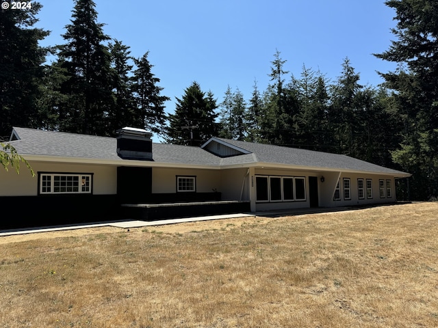 view of front of house with a patio and a front yard