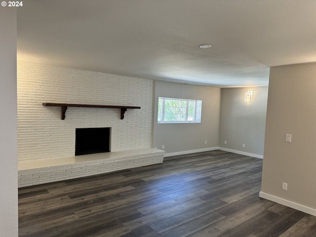 unfurnished living room with a fireplace and dark hardwood / wood-style flooring