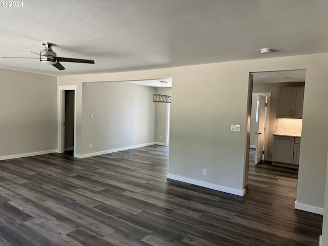 unfurnished room with a textured ceiling, dark hardwood / wood-style floors, and ceiling fan