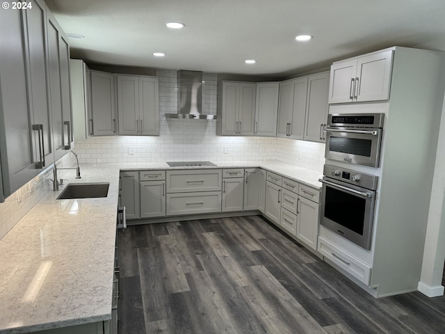 kitchen featuring gray cabinetry, wall chimney exhaust hood, sink, and dark wood-type flooring