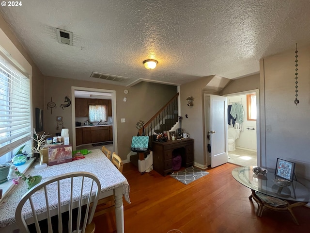 interior space featuring wood-type flooring, a textured ceiling, and a healthy amount of sunlight