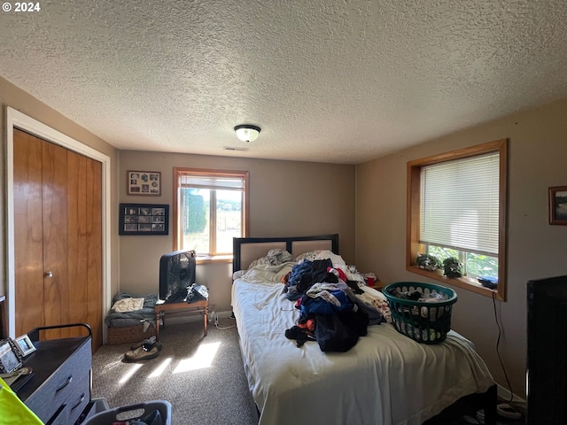 bedroom featuring a textured ceiling, carpet, and a closet