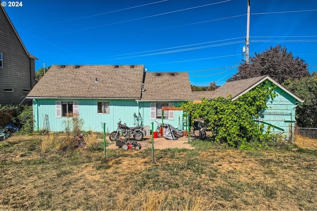 rear view of house with a lawn and a patio