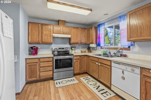 kitchen with sink, light hardwood / wood-style floors, and white appliances