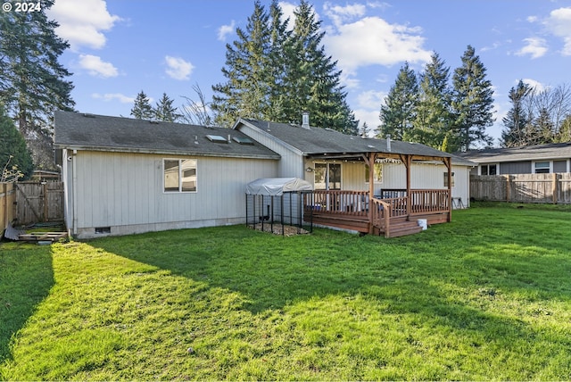 rear view of house with a lawn and a deck