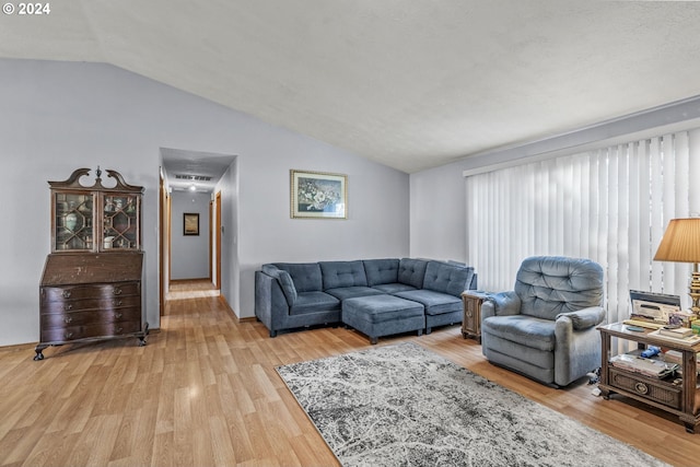 living room with hardwood / wood-style floors and lofted ceiling