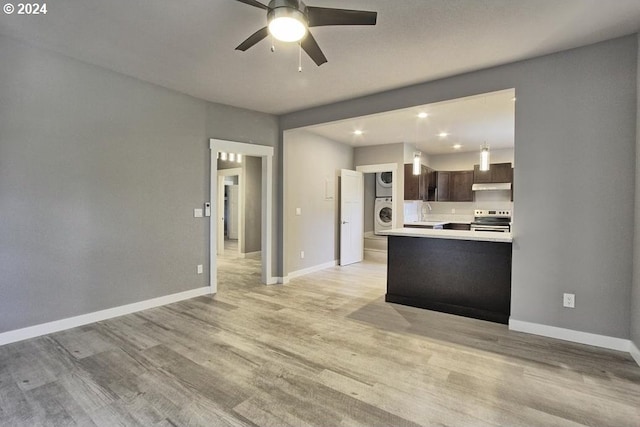 kitchen with stacked washer and dryer, stainless steel electric range, dark brown cabinets, kitchen peninsula, and light wood-type flooring