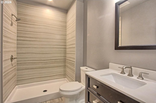 bathroom with walk in shower, vanity, and toilet