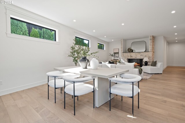 dining space featuring a fireplace and light hardwood / wood-style flooring