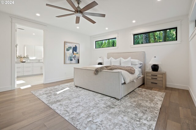 bedroom featuring hardwood / wood-style floors, ensuite bathroom, and ceiling fan