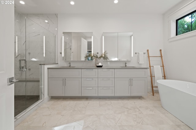 bathroom featuring marble finish floor, a marble finish shower, a freestanding tub, and a sink