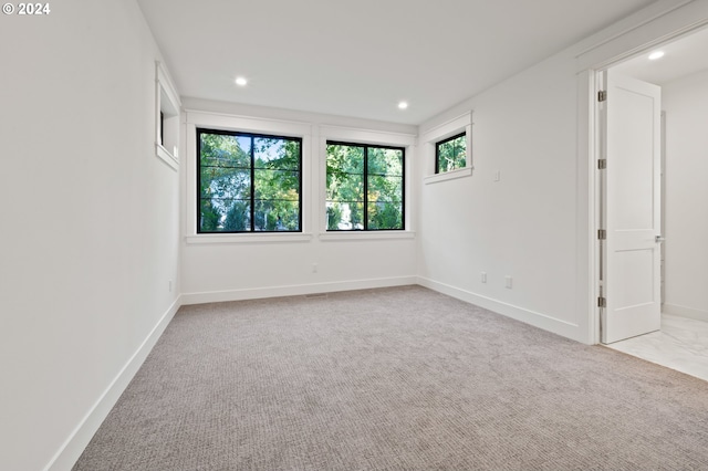 unfurnished room with recessed lighting, light colored carpet, and baseboards