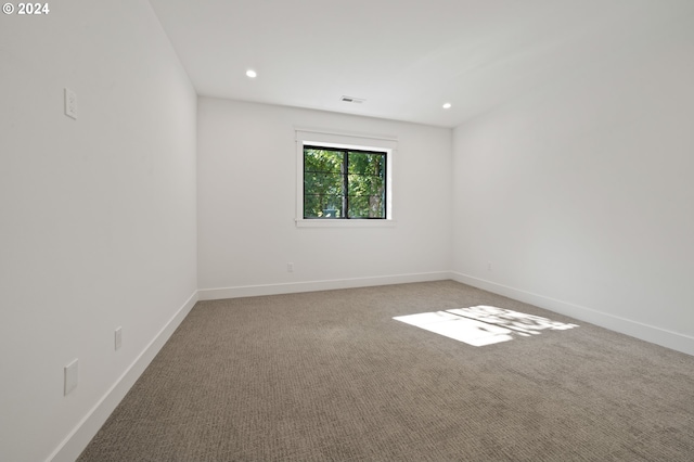 empty room with carpet floors, recessed lighting, visible vents, and baseboards