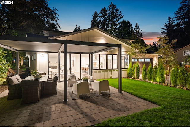 patio terrace at dusk with a lawn and an outdoor living space